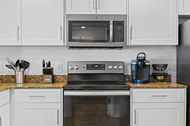 12000 Gulf Blvd Unit 506N, Treasure Island, FL 33706 - kitchen featuring stainless steel appliances, white cabinetry, and stone counters