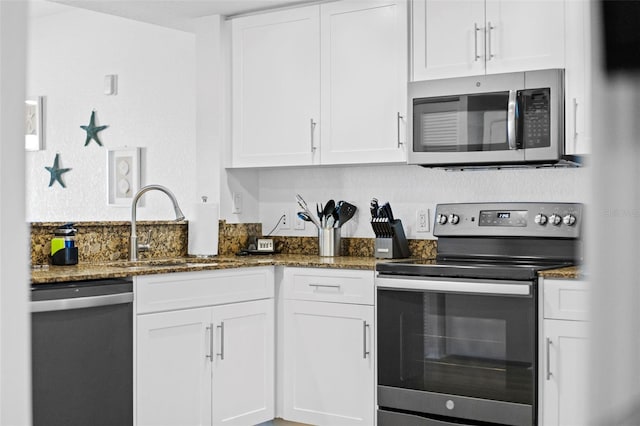 12000 Gulf Blvd Unit 506N, Treasure Island, FL 33706 - kitchen with stainless steel appliances, white cabinets, and dark stone counters