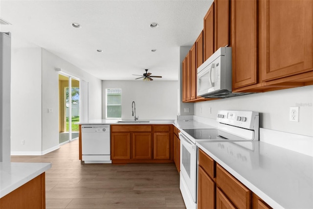 5015 58th Ter E, Bradenton, FL 34203 - kitchen featuring white appliances, brown cabinets, ceiling fan, light wood-style floors, and a peninsula