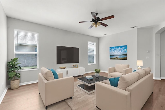 5015 58th Ter E, Bradenton, FL 34203 - living room featuring arched walkways, ceiling fan, healthy amount of natural light, and light wood finished floors