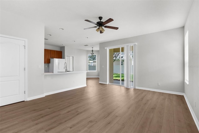5015 58th Ter E, Bradenton, FL 34203 - unfurnished living room with a ceiling fan and wood finished floors