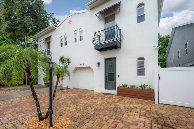 403 S Fremont Ave Unit 3, Tampa, FL 33606 - view of front of home featuring a balcony, stucco siding, an attached garage, and decorative driveway