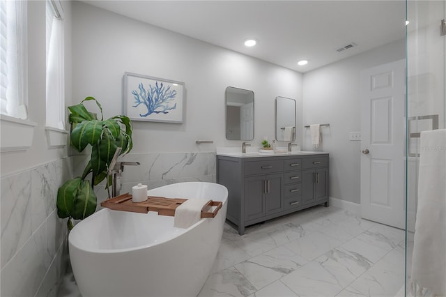 403 S Fremont Ave Unit 3, Tampa, FL 33606 - full bathroom with tile walls, double vanity, marble finish floors, a freestanding tub, and recessed lighting