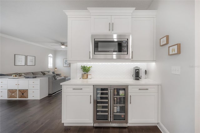 403 S Fremont Ave Unit 3, Tampa, FL 33606 - indoor dry bar with stainless steel microwave, wine cooler, dark wood finished floors, ornamental molding, and decorative backsplash