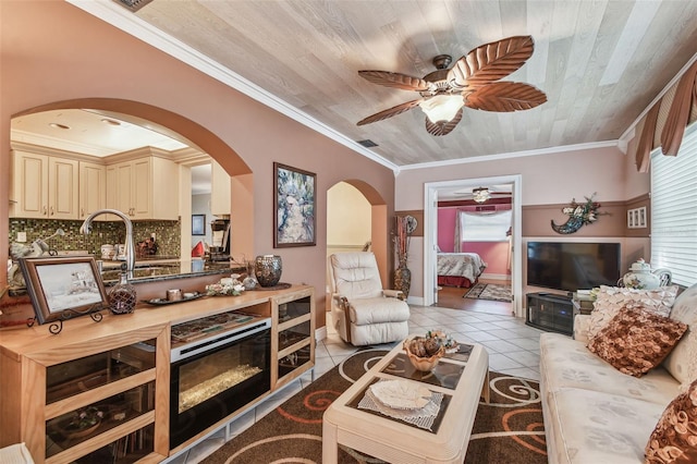 9548 141st St, Seminole, FL 33776 - living room featuring a ceiling fan, arched walkways, light tile patterned flooring, wooden ceiling, and ornamental molding