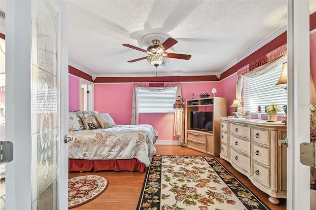 9548 141st St, Seminole, FL 33776 - bedroom featuring multiple windows, wood finished floors, crown molding, a textured ceiling, and a ceiling fan