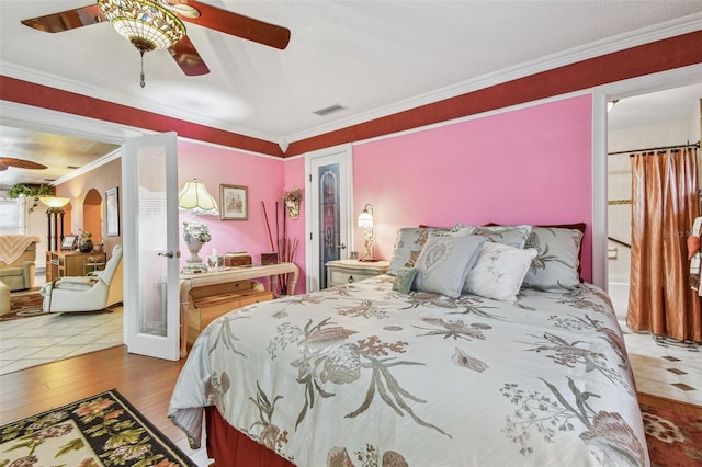 9548 141st St, Seminole, FL 33776 - bedroom featuring wood finished floors, ornamental molding, ceiling fan, arched walkways, and french doors