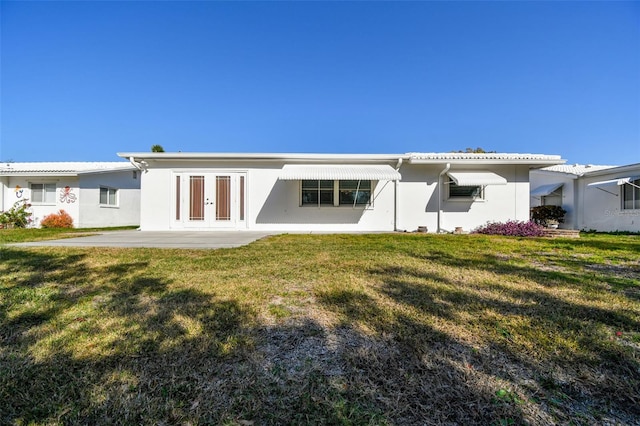 9548 141st St, Seminole, FL 33776 - rear view of house featuring stucco siding, french doors, and a yard