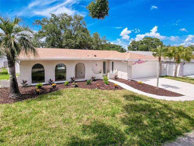 603 Ivey Ln, Tarpon Springs, FL 34689 - ranch-style house featuring stucco siding, concrete driveway, an attached garage, and a front lawn
