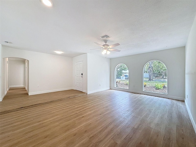 603 Ivey Ln, Tarpon Springs, FL 34689 - empty room with arched walkways, wood finished floors, and a ceiling fan