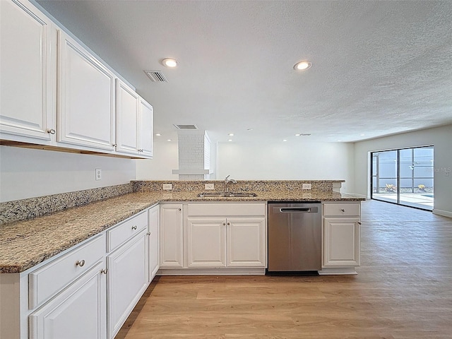 603 Ivey Ln, Tarpon Springs, FL 34689 - kitchen with stainless steel dishwasher, light wood finished floors, a peninsula, white cabinets, and stone countertops