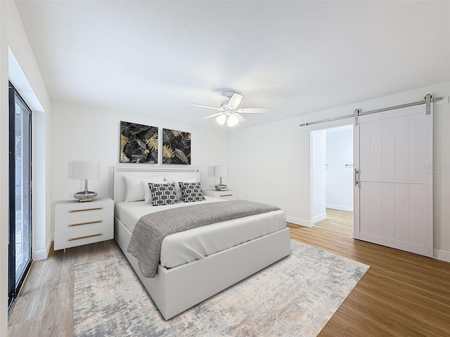 603 Ivey Ln, Tarpon Springs, FL 34689 - bedroom featuring a barn door, wood finished floors, and ceiling fan