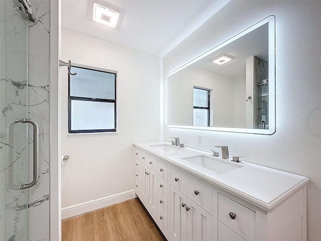 603 Ivey Ln, Tarpon Springs, FL 34689 - full bathroom featuring a marble finish shower, double vanity, wood finished floors, and plenty of natural light