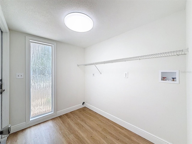 603 Ivey Ln, Tarpon Springs, FL 34689 - laundry area featuring washer hookup, light wood finished floors, and a textured ceiling