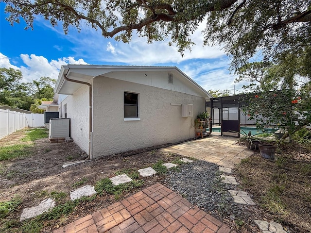 603 Ivey Ln, Tarpon Springs, FL 34689 - rear view of house with stucco siding and a patio