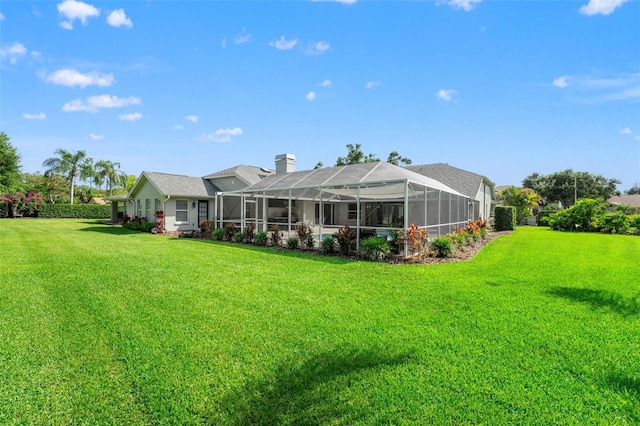 17311 Carriage Way, Odessa, FL 33556 - rear view of house with a chimney, a yard, and glass enclosure