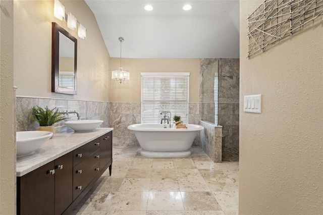 17311 Carriage Way, Odessa, FL 33556 - bathroom with a freestanding bath, double vanity, tile walls, walk in shower, and vaulted ceiling