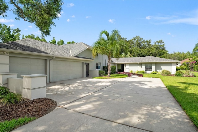 17311 Carriage Way, Odessa, FL 33556 - ranch-style house featuring a garage, stucco siding, driveway, a front lawn, and a shingled roof