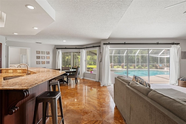 17311 Carriage Way, Odessa, FL 33556 - living area with light marble finish flooring, a textured ceiling, and recessed lighting