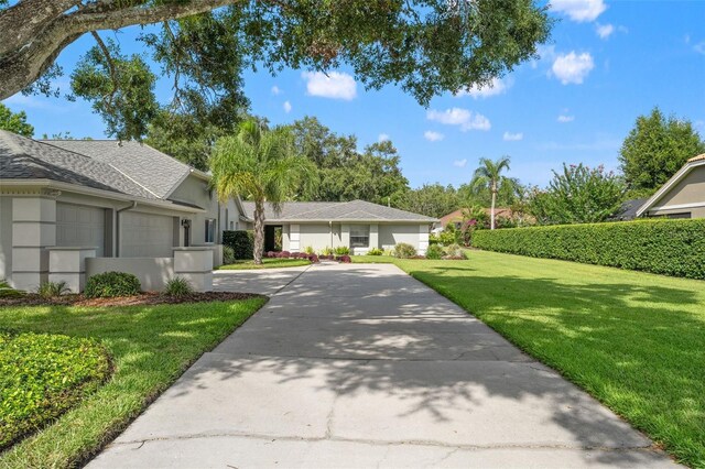17311 Carriage Way, Odessa, FL 33556 - view of front of house with concrete driveway, a garage, a front lawn, and stucco siding