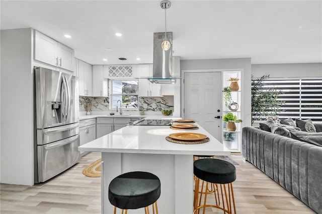 1384 S Hillcrest Ave, Clearwater, FL 33756 - kitchen featuring stainless steel refrigerator with ice dispenser, exhaust hood, light wood-style flooring, light countertops, and recessed lighting