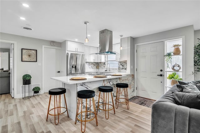 1384 S Hillcrest Ave, Clearwater, FL 33756 - kitchen featuring stainless steel fridge with ice dispenser, open floor plan, island exhaust hood, a peninsula, and recessed lighting