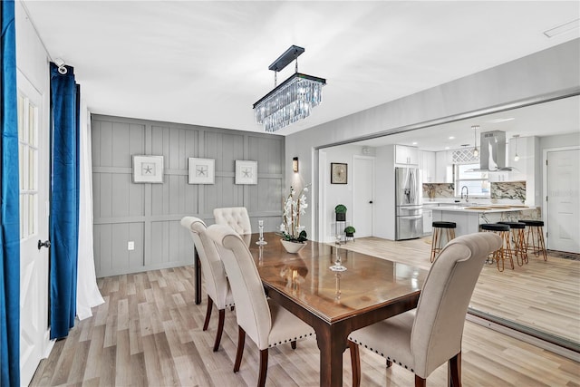 1384 S Hillcrest Ave, Clearwater, FL 33756 - dining room with a chandelier, light wood finished floors, and a decorative wall