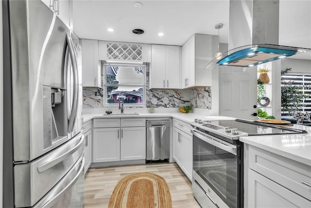 1384 S Hillcrest Ave, Clearwater, FL 33756 - kitchen with stainless steel appliances, island range hood, light wood-type flooring, backsplash, and recessed lighting