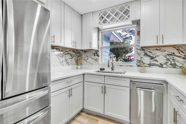 1384 S Hillcrest Ave, Clearwater, FL 33756 - kitchen with appliances with stainless steel finishes, decorative backsplash, white cabinets, light wood-style floors, and light stone countertops