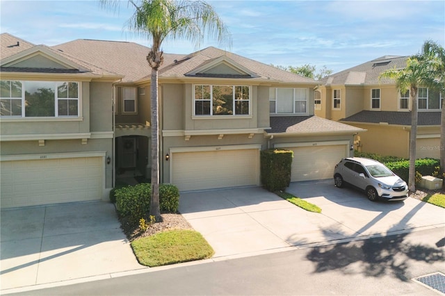 6677 84th Ave N, Pinellas Park, FL 33781 - multi unit property featuring stucco siding, driveway, a garage, and roof with shingles