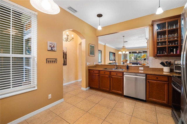 6677 84th Ave N, Pinellas Park, FL 33781 - kitchen featuring stainless steel dishwasher, arched walkways, light tile patterned flooring, brown cabinetry, and crown molding