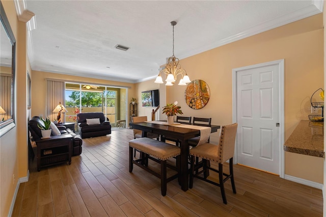 6677 84th Ave N, Pinellas Park, FL 33781 - dining space with wood finished floors, ornamental molding, and a chandelier