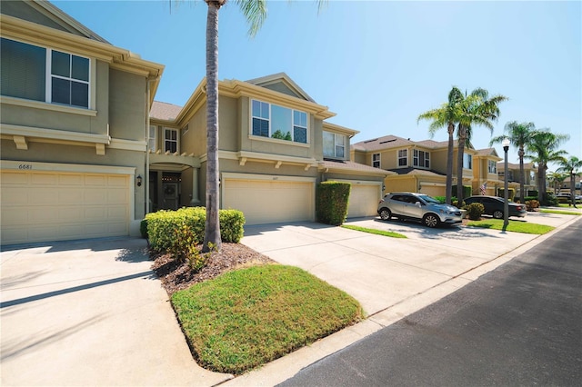 6677 84th Ave N, Pinellas Park, FL 33781 - view of property featuring a garage, concrete driveway, a residential view, and stucco siding