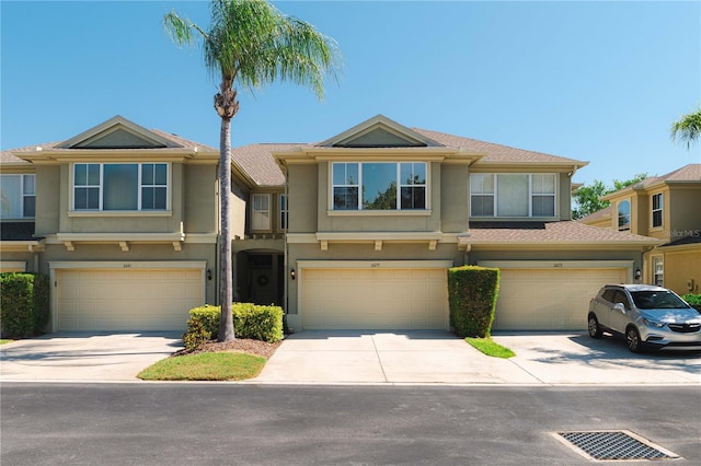 6677 84th Ave N, Pinellas Park, FL 33781 - townhome / multi-family property featuring an attached garage, stucco siding, and driveway