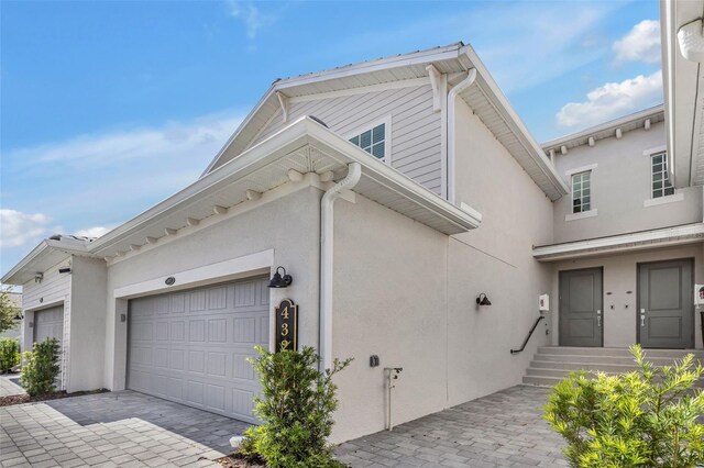 43250 Water Bird Way Unit 5921, Punta Gorda, FL 33982 - view of side of property with stucco siding, a garage, and decorative driveway