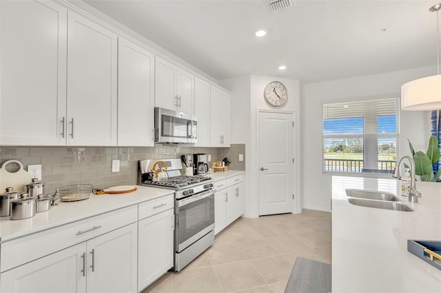 43250 Water Bird Way Unit 5921, Punta Gorda, FL 33982 - kitchen featuring stainless steel appliances, tasteful backsplash, white cabinets, light countertops, and light tile patterned floors