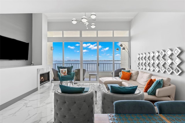 5153 Isla Key Blvd S Unit 415, Saint Petersburg, FL 33715 - living room featuring marble finish flooring, a chandelier, a water view, a towering ceiling, and a high end fireplace