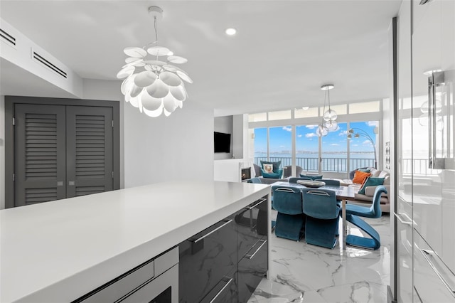 5153 Isla Key Blvd S Unit 415, Saint Petersburg, FL 33715 - kitchen with a chandelier, light countertops, floor to ceiling windows, light marble finish floors, and open floor plan