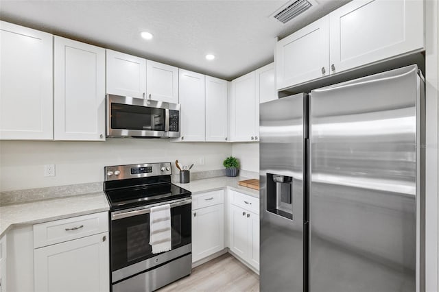 6521 Bimini Ct, Apollo Beach, FL 33572 - kitchen with appliances with stainless steel finishes, light countertops, white cabinetry, and recessed lighting