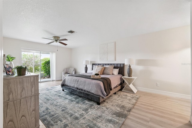 6521 Bimini Ct, Apollo Beach, FL 33572 - bedroom with light wood finished floors, a ceiling fan, a textured ceiling, and access to outside