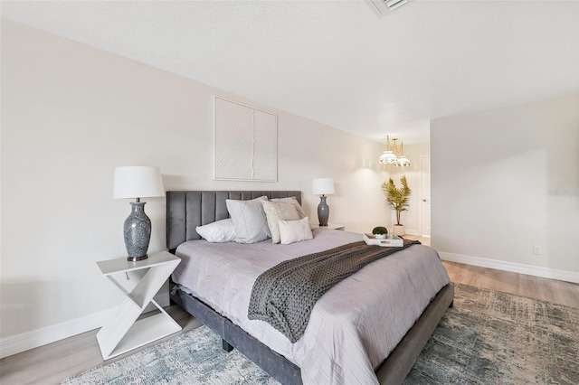 6521 Bimini Ct, Apollo Beach, FL 33572 - bedroom featuring wood finished floors and a chandelier