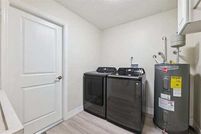 6521 Bimini Ct, Apollo Beach, FL 33572 - laundry room featuring water heater, washing machine and clothes dryer, light wood-type flooring, cabinet space, and a textured ceiling