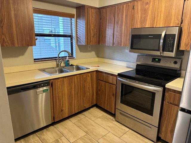 101 Lake Ave NE Unit 121, Largo, FL 33771 - kitchen featuring appliances with stainless steel finishes, light countertops, and brown cabinets