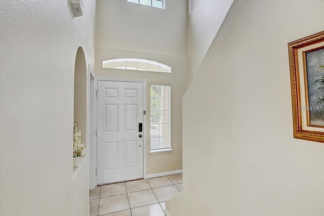 10437 River Bream Dr, Riverview, FL 33569 - foyer entrance featuring arched walkways, light tile patterned flooring, plenty of natural light, and a towering ceiling