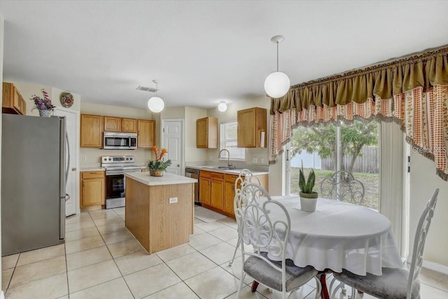 10437 River Bream Dr, Riverview, FL 33569 - kitchen featuring stainless steel appliances, light countertops, a kitchen island, decorative light fixtures, and light tile patterned floors