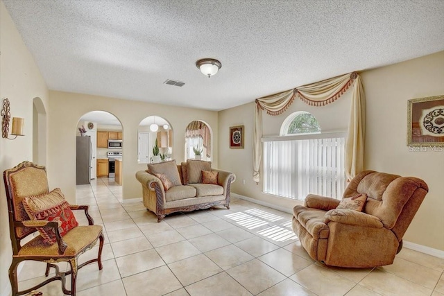 10437 River Bream Dr, Riverview, FL 33569 - living room with arched walkways, light tile patterned floors, and a textured ceiling