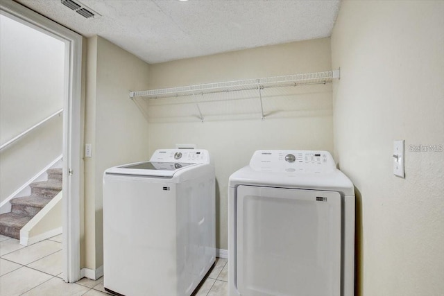 10437 River Bream Dr, Riverview, FL 33569 - washroom featuring washing machine and clothes dryer, light tile patterned floors, and a textured ceiling