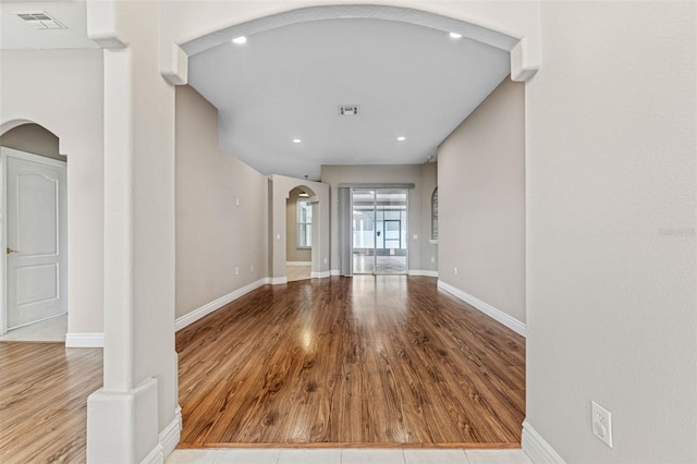 25946 Buckthorn Ave, Land O Lakes, FL 34639 - unfurnished living room with arched walkways, wood finished floors, and recessed lighting
