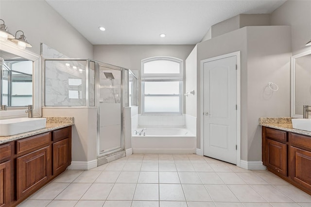 25946 Buckthorn Ave, Land O Lakes, FL 34639 - bathroom featuring a stall shower, two vanities, a bath, tile patterned floors, and recessed lighting