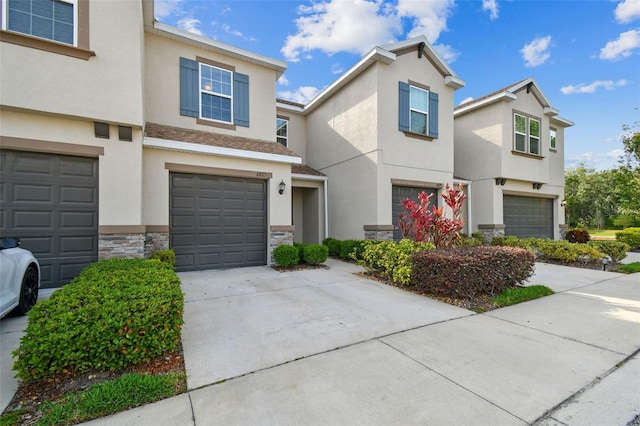 6825 Citrus Creek Ln, Tampa, FL 33625 - view of property featuring a garage, stucco siding, driveway, and stone siding